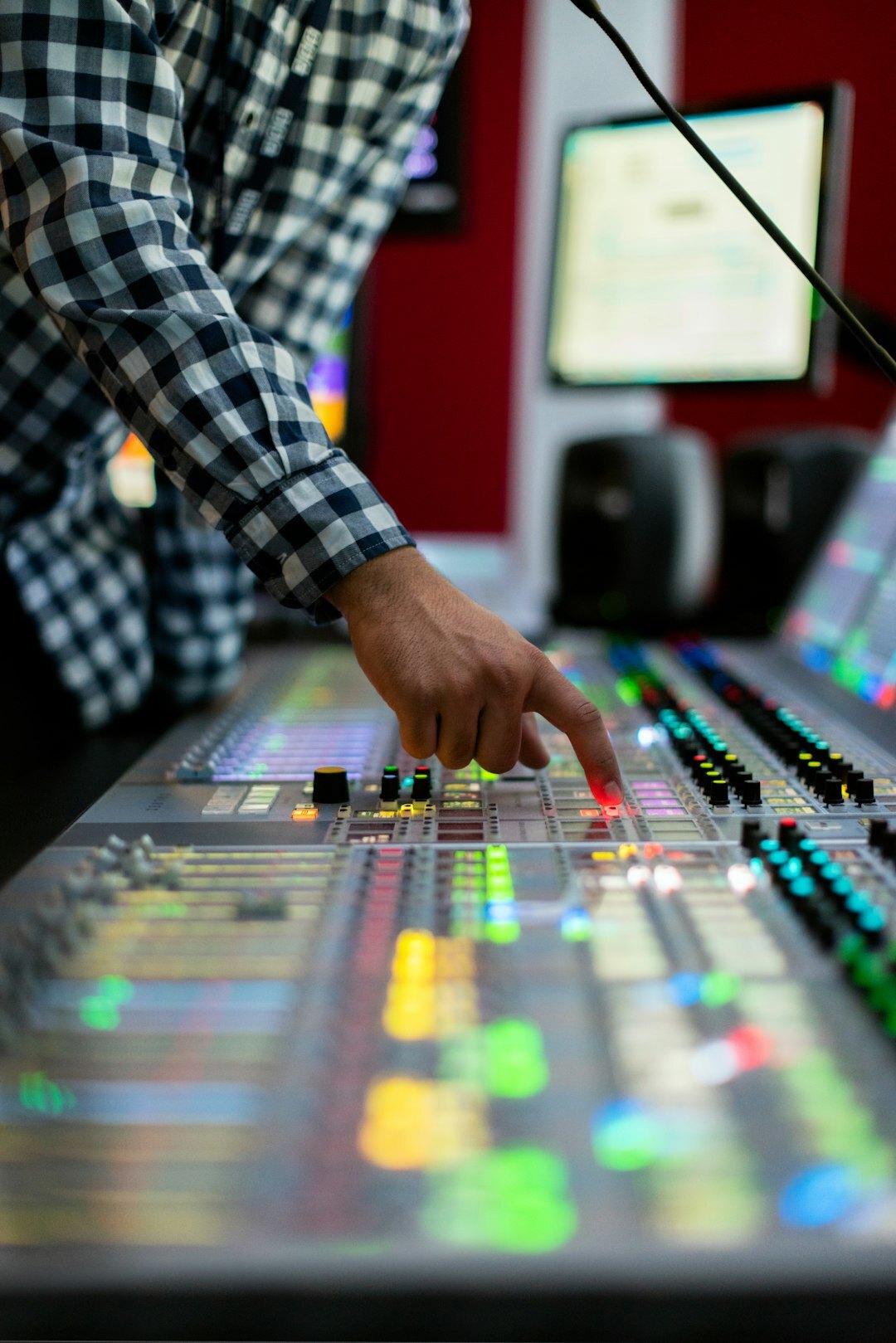 Audio mixing console with sound wave meters in a broadcast studio